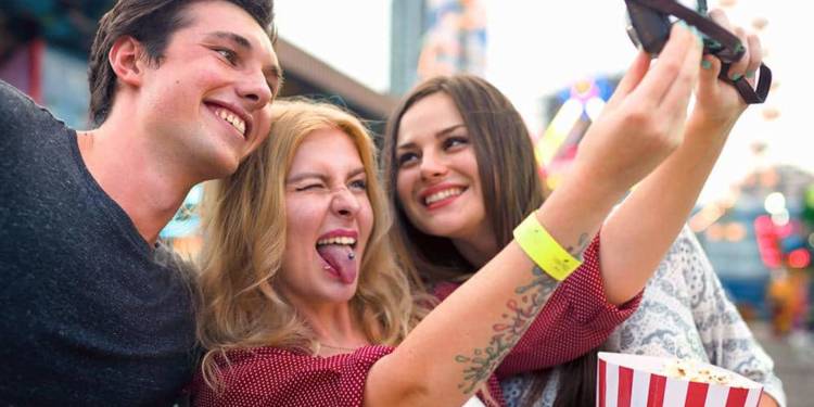 Jugendliche machen ein Selfie auf einer Kirmes
