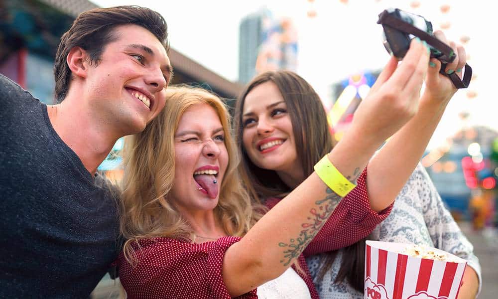 Jugendliche machen ein Selfie auf einer Kirmes