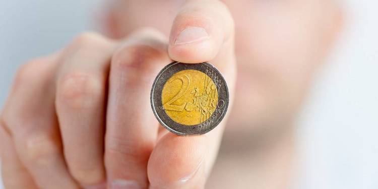 Ein Mann hält eine 2 Euro Münze