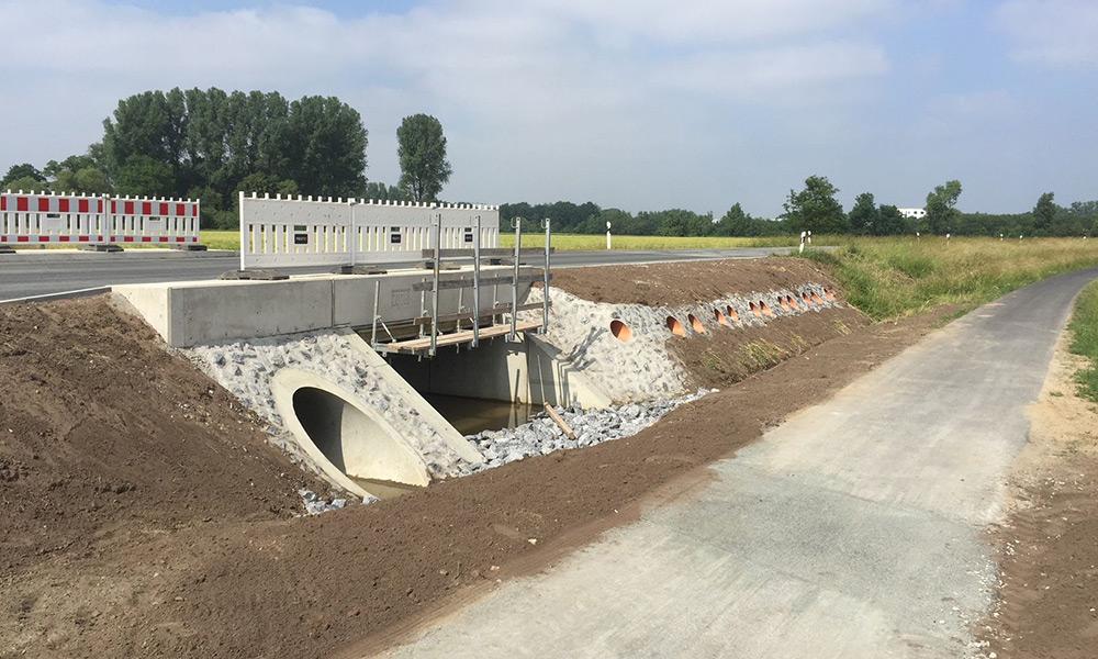 Die Flutbrücke an der Möhlerstraße ist fertig gestellt: Bei Hochwasser gibt es drei Arten von Durchlässen: Den großen rechteckigen, den danebenliegenden großen runden und die zwölf Rohre, die in die verfüllte alte Flutbrücke eingearbeitet worden sind. - © Kreis Gütersloh