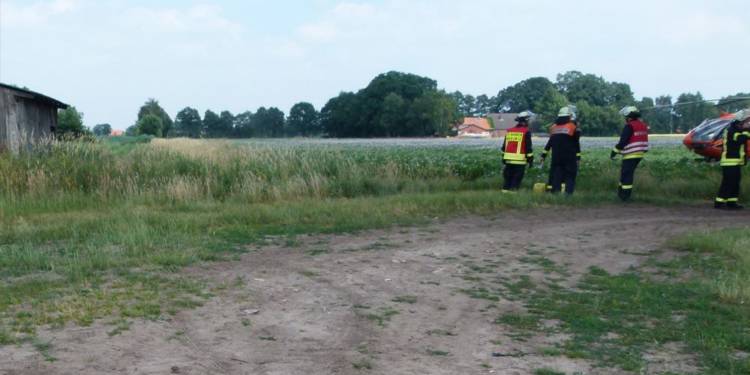 Der im Graben liegende Traktor wurde von dem hohen Gras verdeckt. Der Rettungshubschrauber landete rechts davon in unmittelbarer Nähe - © Polizei Rahden