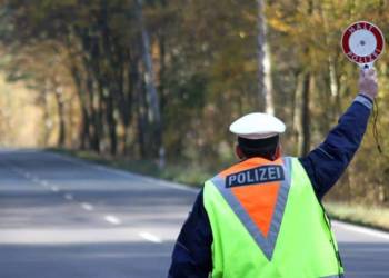 Polizist hält Auto mit einer Polizeikelle an